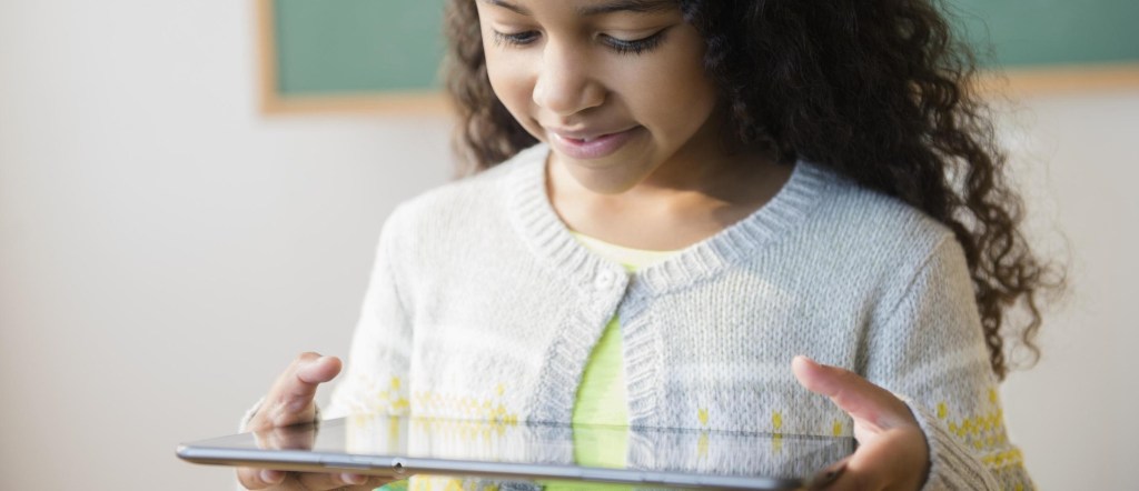 Niña usando la tablet aprendiendo competencias digitales